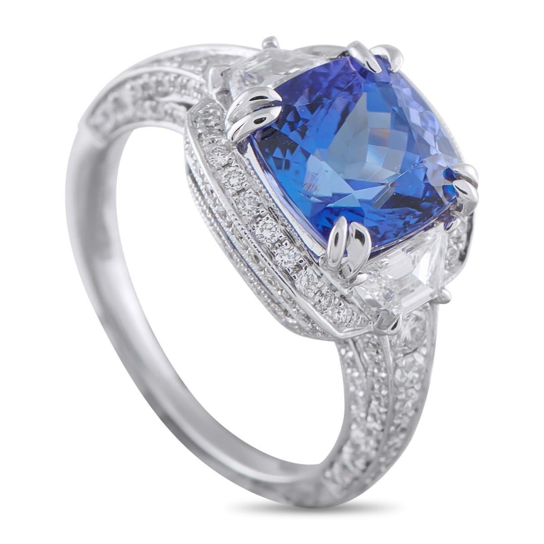 18K WHITE GOLD 1.10CT DIAMOND AND TANZANITE RING: Certain rings are destined for formal settings, and this piece carries that assurance. At its center lies a 3.40-carat tanzanite secured by double claw prongs at each corner. Trapezoid diamonds flank