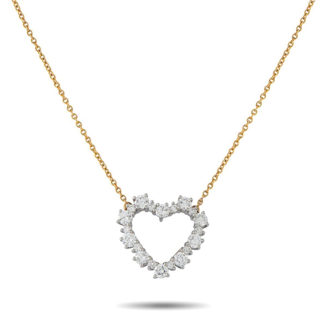 TIFFANY & CO. 18K WHITE AND YELLOW GOLD 0.63CT DIAMOND HEART NECKLACE: This charming Tiffany & Co. necklace will instantly add a touch of sparkle to any ensemble. Crafted from a combination of 18K White Gold and 18K Yellow Gold, the heart-shaped pendant at the center shi