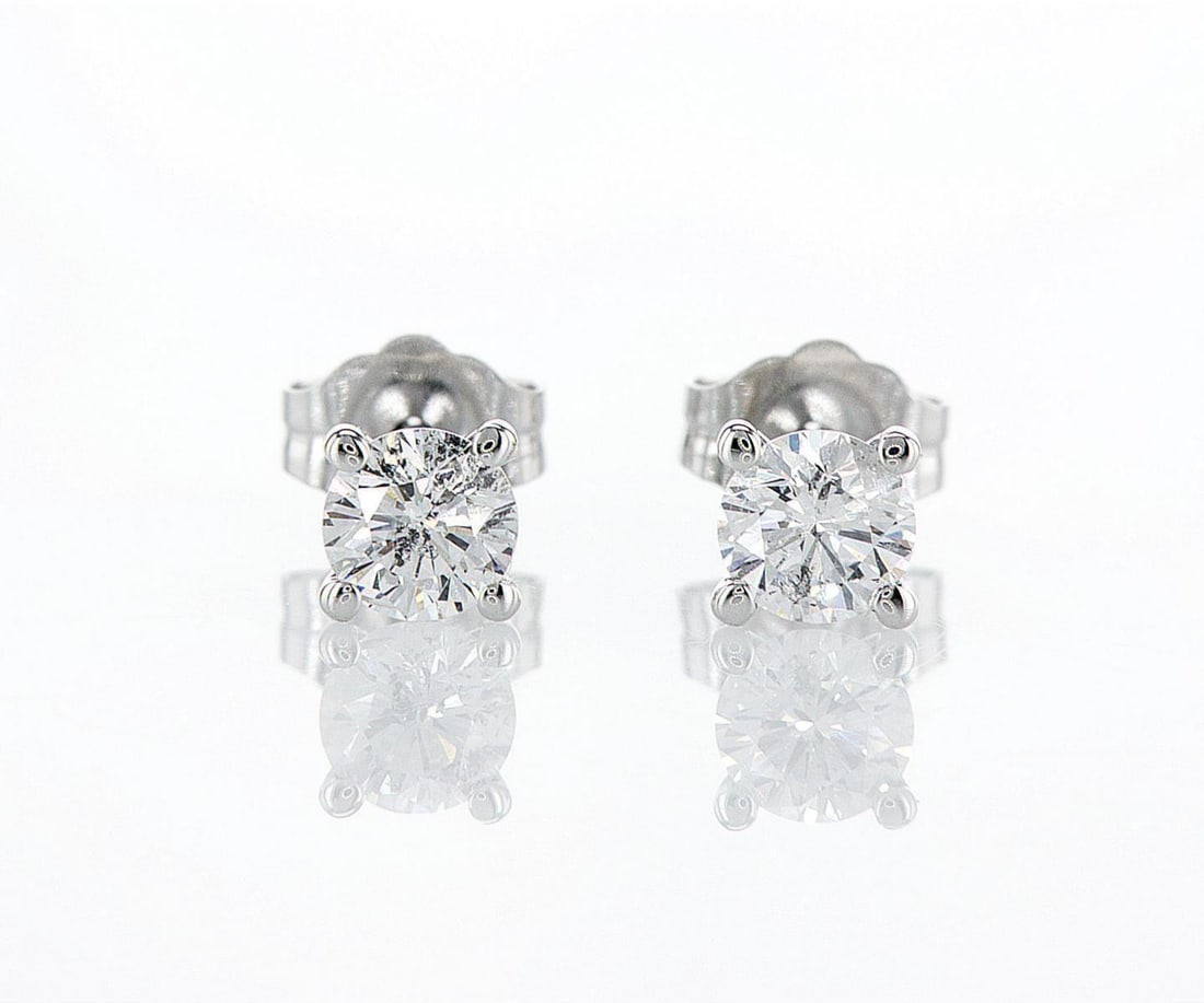 14kt White Gold 0.66ctw Diamond Earrings: One pair of 14k white gold earrings (14k stamped), each set with one natural diamond. Jewelry Weight: 0.73Grs Total Diamonds Weight: 0.66Cts Main Stones Description: Quantity: 2 Cut and shape: Round B