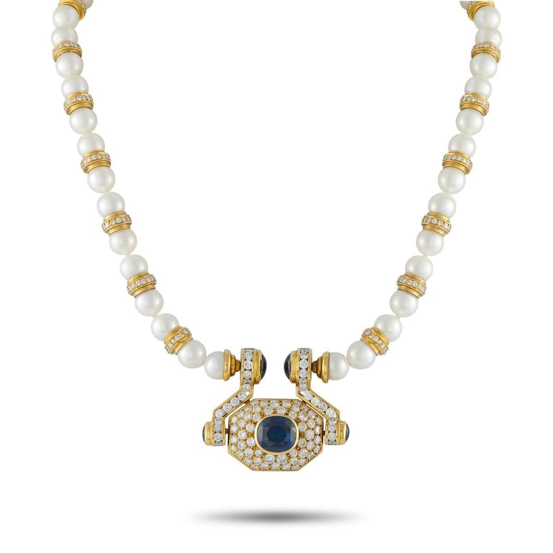 18K YELLOW GOLD 7.0CT DIAMOND AND SAPPHIRE STATEMENT NECKLACE: Nothing understated here. At the center, a door knocker-inspired pendant frames a 10-carat blue sapphire, bezel-set and surrounded by diamonds across an octagonal face. Two smaller sapphires rest at t