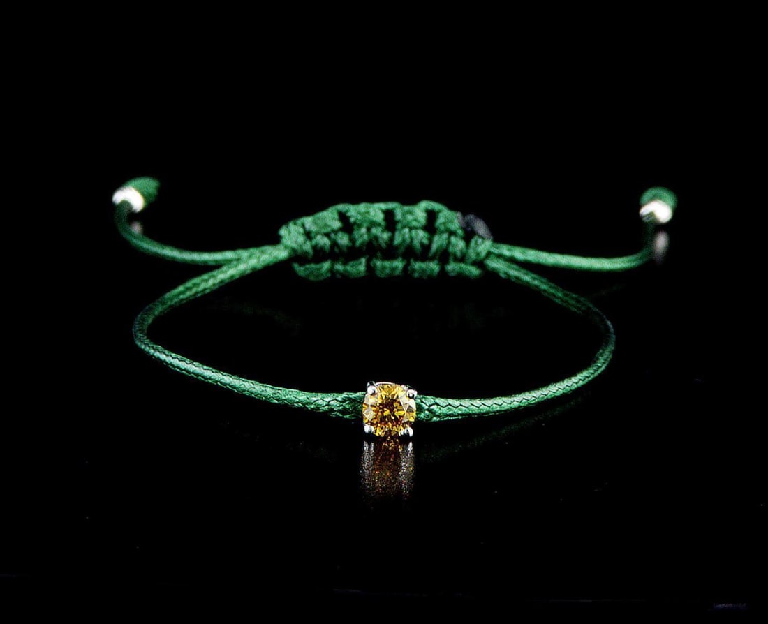 14kt White Gold 0.3ctw Diamond Bracelet: One 14k white gold bracelet "Green Cord", set with one center natural color treated diamond. Jewelry Weight: 0.8Grs Total Diamonds Weight: 0.3Cts Main Stones Description: Quantity: 1 Cut and shape: Ro