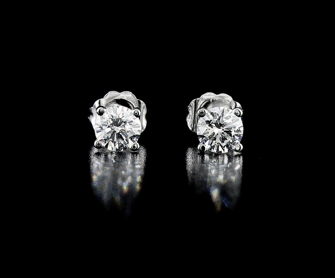 18kt White Gold 0.79ctw Diamond Earrings: One pair of 14k white gold earrings (14k stamped), each set with one natural diamond. Jewelry Weight: 0.86Grs Total Diamonds Weight: 0.79Cts Main Stones Description: Quantity: 2 Cut and shape: Round B
