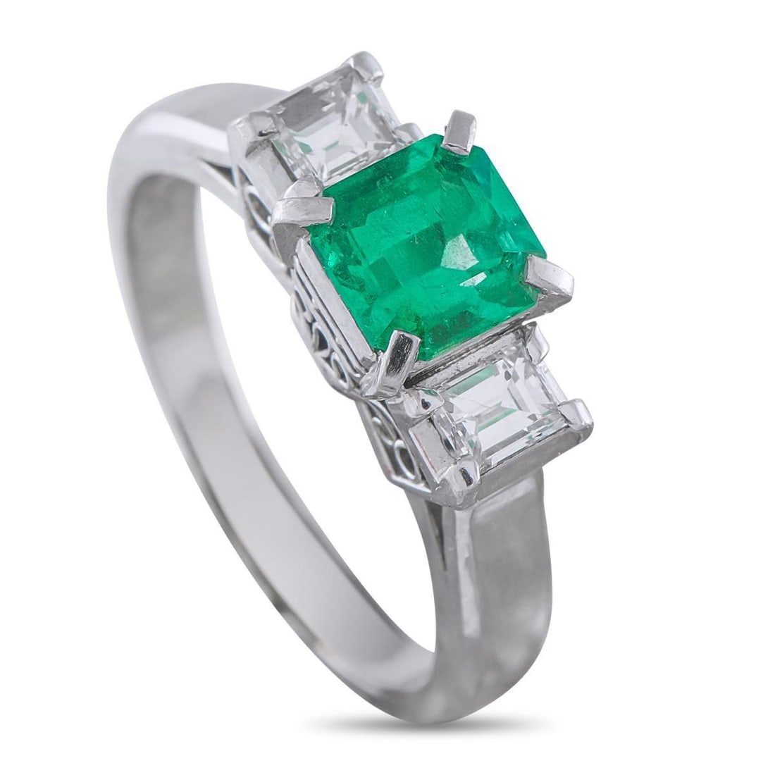 PLATINUM 0.36CT DIAMOND AND EMERALD RING: A classic three-stone design makes this luxury ring simple timeless. The ornate Platinum setting adds extra vintage elegance to this stylish piece. At the center, a 0.86 carat Emerald is flanked by Di