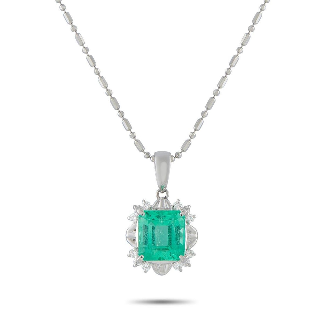 PLATINUM 0.16CT DIAMOND AND EMERALD PENDANT NECKLACE: This classically elegant necklace will add a stylish pop of color to any ensemble. A 3.10 carat Emerald makes it instantly captivating, while Diamond accents totaling 0.16 carats further elevate this 