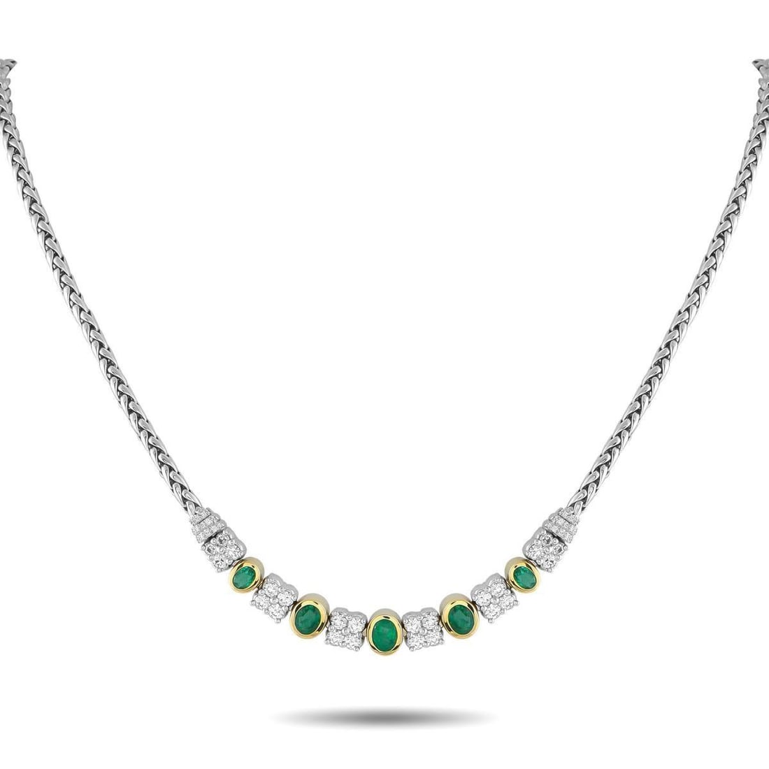 18K WHITE AND YELLOW GOLD 1.65CT DIAMOND AND EMERALD NECKLACE: An exquisite creation of style and presence. This piece features a substantial woven chain, polished in the style of a wheat braid, that lends texture and strength. At its center are tapering oval eme