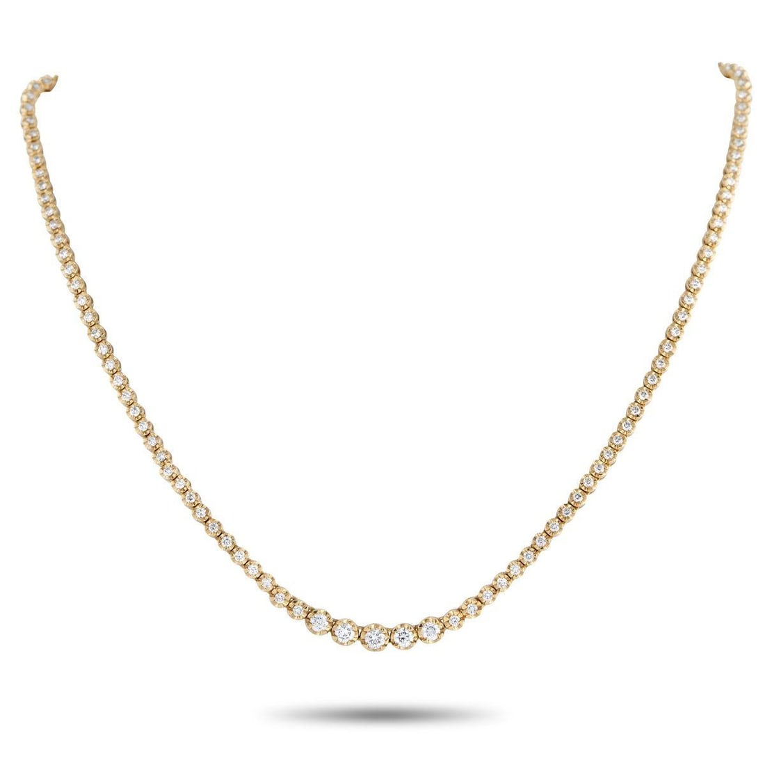 18K YELLOW GOLD 3.0CT DIAMOND LINE NECKLACE: Rather than following the standard tennis necklace layout, this 18K yellow gold diamond line necklace introduces a point of emphasis at its center. A short row of larger diamonds forms the focal point