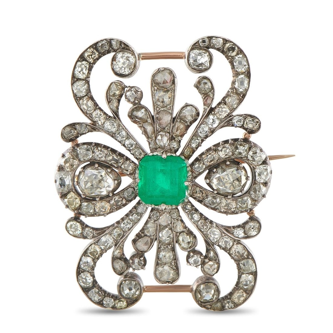 ANTIQUE 18K ROSE GOLD AND SILVER 4.0CT DIAMOND AND EMERALD BROOCH: Sparkling Diamonds with a total weight of 4.0 carats allow this antique brooch to effortlessly catch the light. Crafted from a combination of 18K Rose Gold and Silver, a 2.0 carat Emerald center stone
