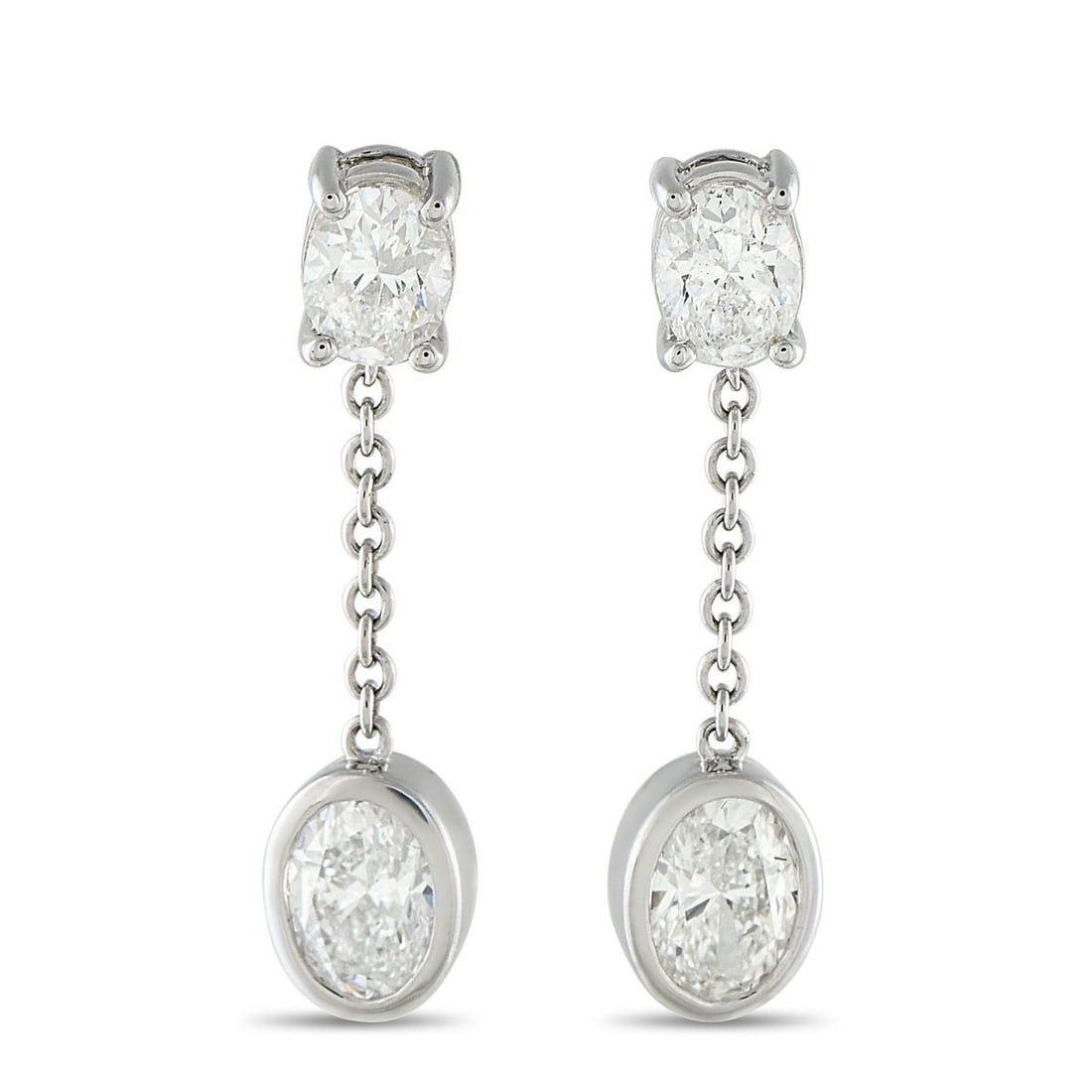 18K WHITE GOLD 2.50CT OVAL DIAMOND DANGLE EARRINGS: Shining with every step, the gentle sway of these dangles reflects light from every angle, scattering light in a way no stud can match. An oval diamond in four prongs anchors the post. From it hangs a