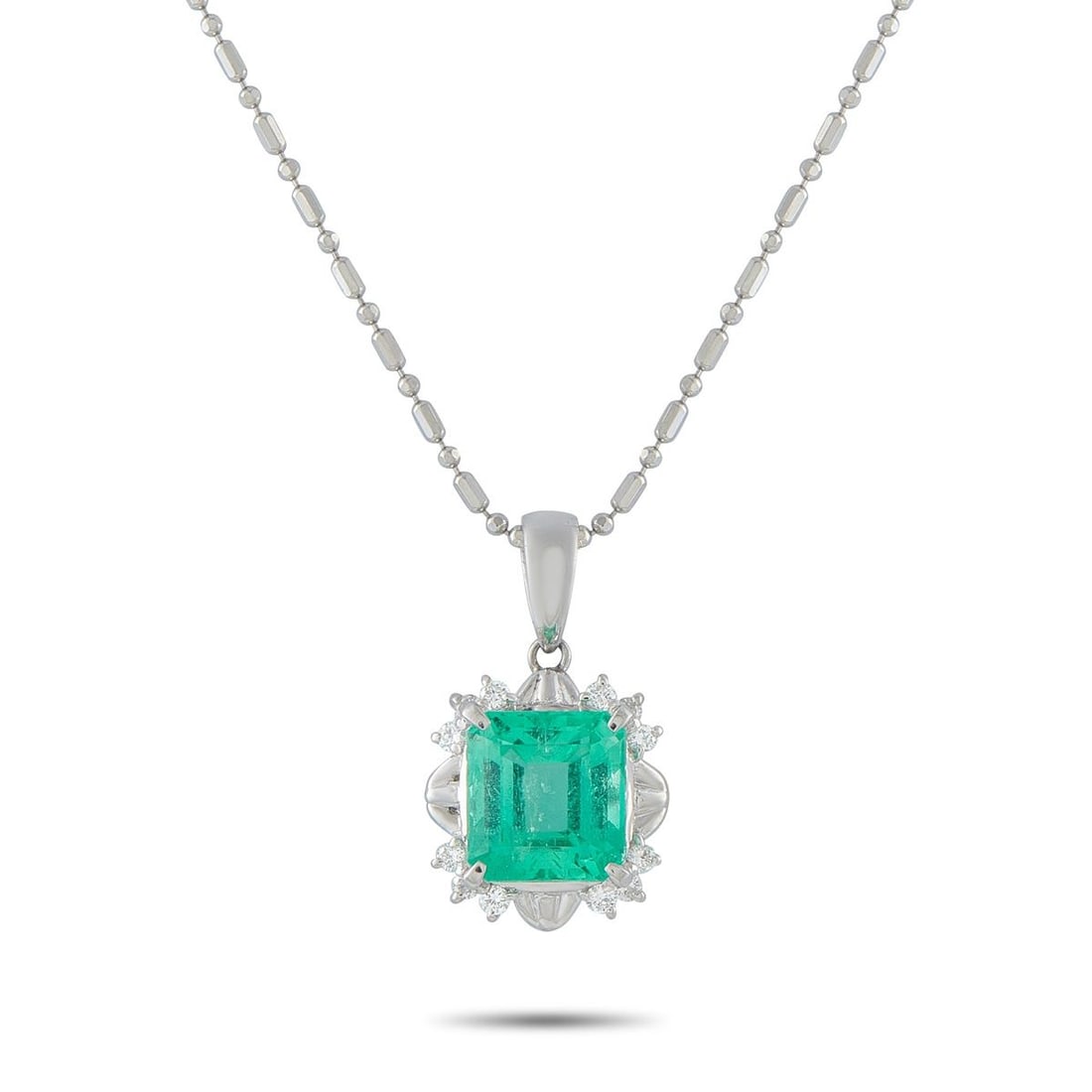PLATINUM 0.16CT DIAMOND AND EMERALD PENDANT NECKLACE: This classically elegant necklace will add a stylish pop of color to any ensemble. A 3.10 carat Emerald makes it instantly captivating, while Diamond accents totaling 0.16 carats further elevate this 