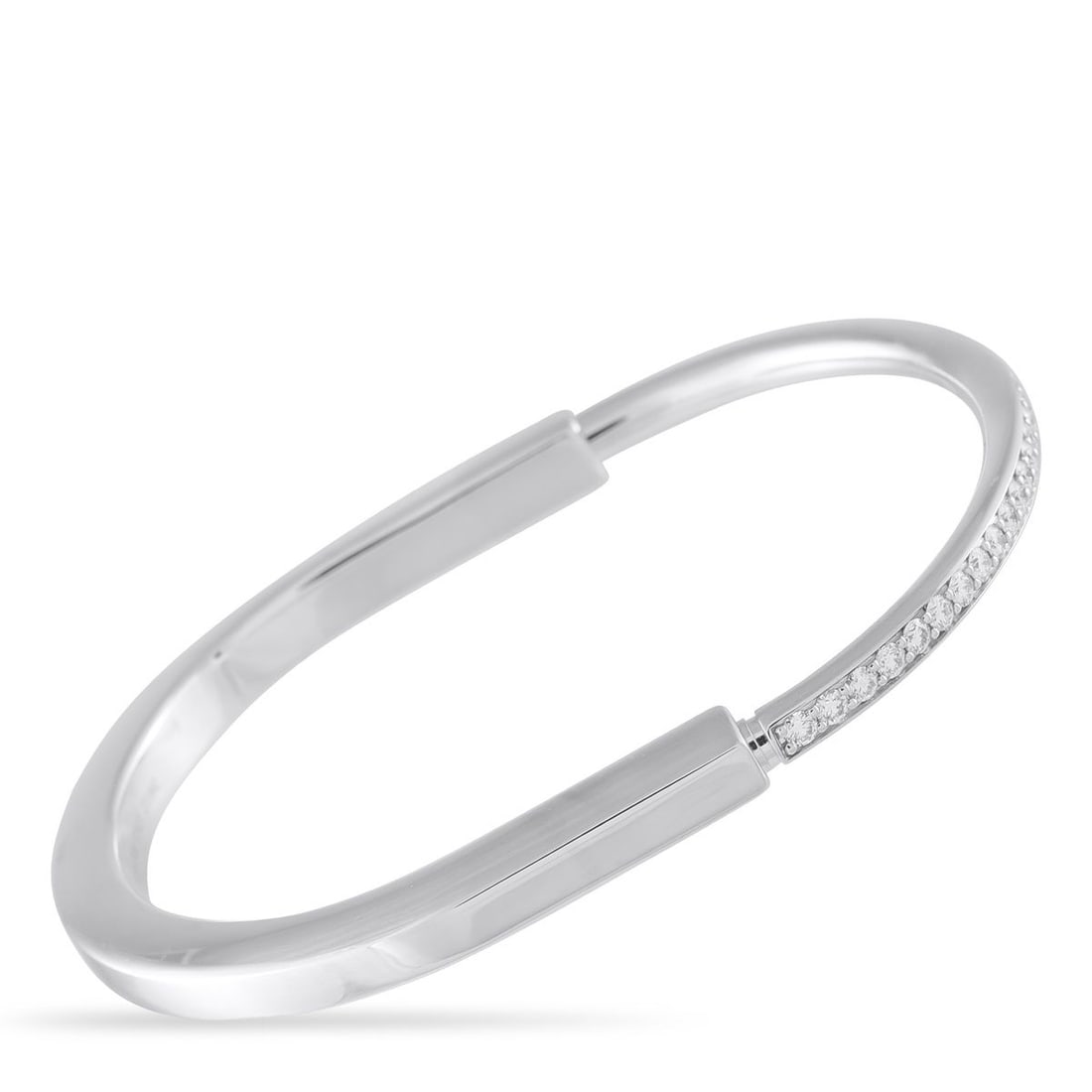 TIFFANY & CO. LOCK 18K WHITE GOLD 1.20CT DIAMOND BANGLE BRACELET: This Tiffany & Co. Lock bangle bracelet was originally inspired by a padlock found in The Tiffany Archives. The sleek, sophisticated design comes to life thanks to sparkling inset Diamonds with a tota