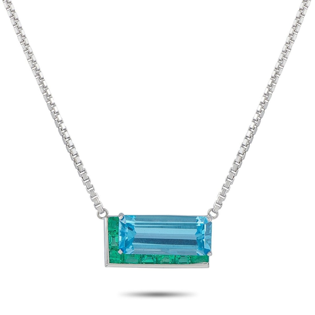 PLATINUM AND 18K WHITE GOLD 1.20CT EMERALD AND TOPAZ NECKLACE: Bold colors come together in perfect harmony on this unforgettable necklace. Crafted from a combination of Platinum and 18K White Gold, this piece features a striking pendant at the center of a 20 box