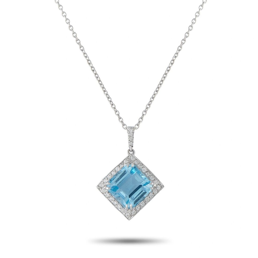 14K WHITE GOLD 0.25CT DIAMOND AND TOPAZ PENDANT NECKLACE: This pendant necklace is crafted in 14K white gold and features a kite-shaped design centered with a vibrant emerald-cut blue topaz, framed by a halo of round brilliant-cut diamonds totaling approxima