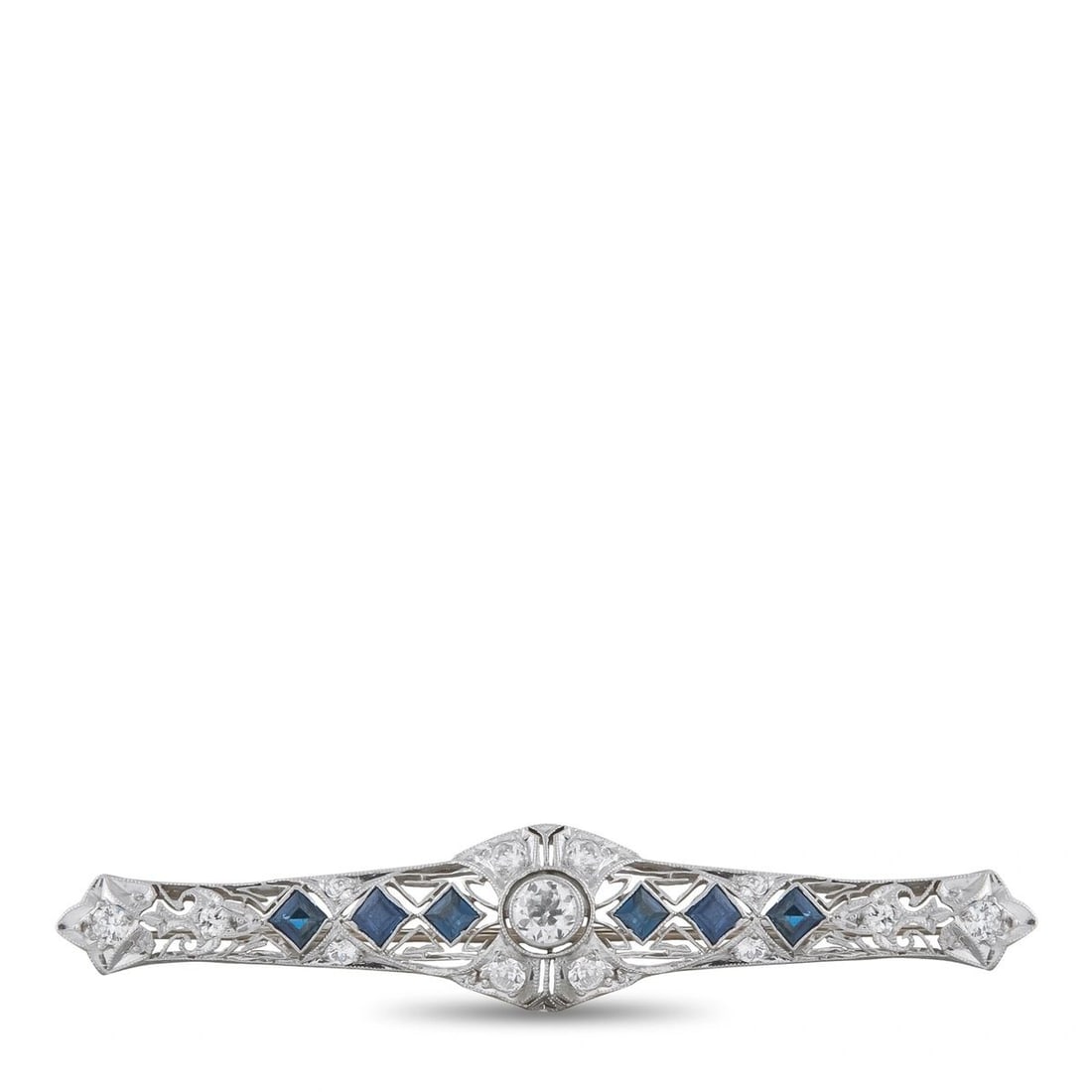 PLATINUM 0.90CT DIAMOND AND SAPPHIRE BROOCH: Art Deco elements make this luxury brooch an instant classic. Set in Platinum, Diamonds with a total weight of 0.90 carats allow it to effortlessly emanate light. Sapphire accents offer an exciting po
