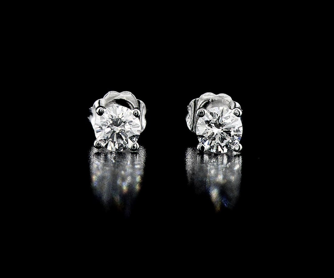 18kt White Gold 0.79ctw Diamond Earrings: One pair of 14k white gold earrings (14k stamped), each set with one natural diamond. Jewelry Weight: 0.86Grs Total Diamonds Weight: 0.79Cts Main Stones Description: Quantity: 2 Cut and shape: Round B