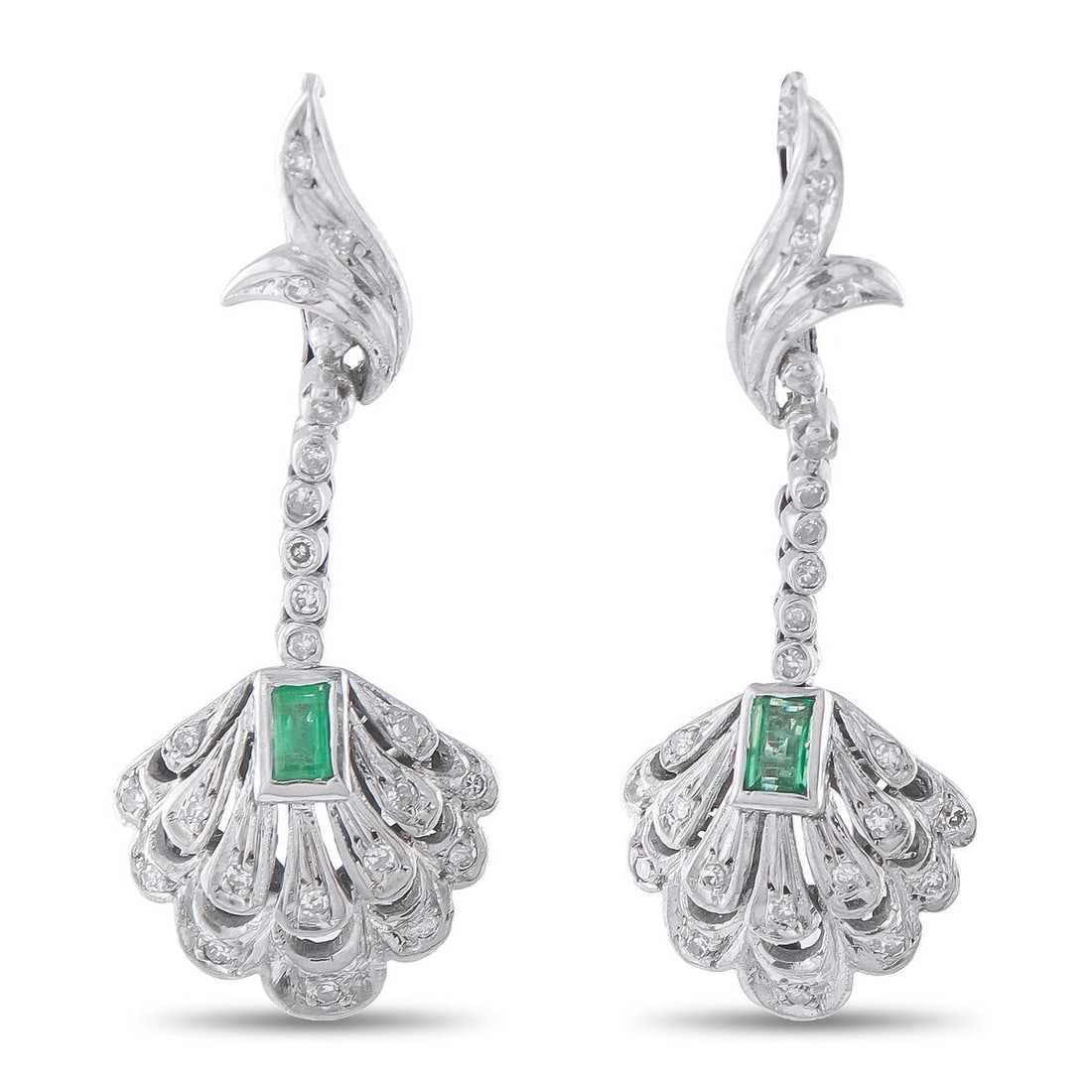 ANTIQUE 18K WHITE GOLD DIAMOND AND EMERALD EARRINGS: This estate pair of antique-style 18K white gold dangle earrings showcases a diamond-set flame motif suspending a scalloped, fan-shaped drop centered with a bezel-set emerald-cut emerald. The earrings