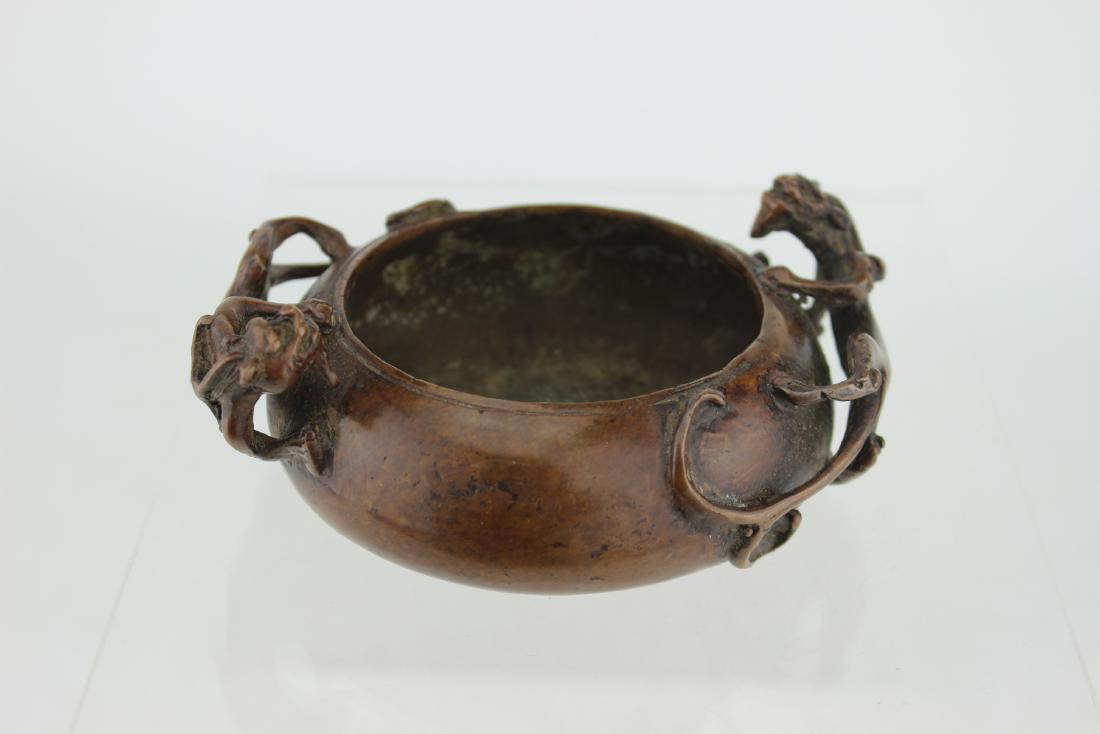A CHINESE BRONZE CENSER: The censer with two dragon decoration and engraved mark on the bottom. 5:D X 1 3/4"H.
