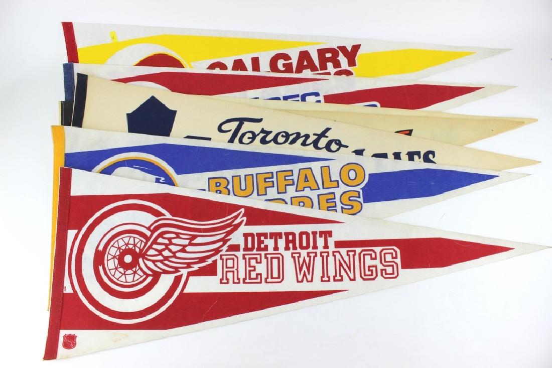 SEVEN ASSORTED NHL PENNANTS: Including: Buffalo Sabres, Detroit Red Wings, Toronto Maple Leafs, Philadelphia Flyers, Montreal Canadiens, Quebec Nordiques, Calgary Flames teams. Each pennant measures 30"L X 12"W.