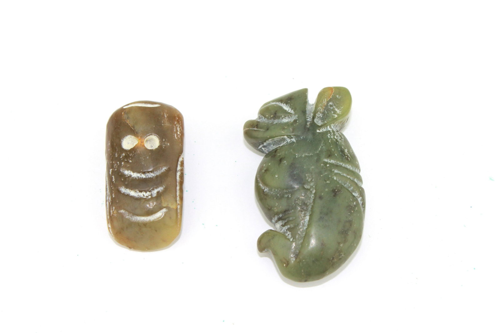 TWO CHINESE JADE CARVINGS: One jade cicada measures 40 mm in length, and one animal carving measures 55 mm in length.
