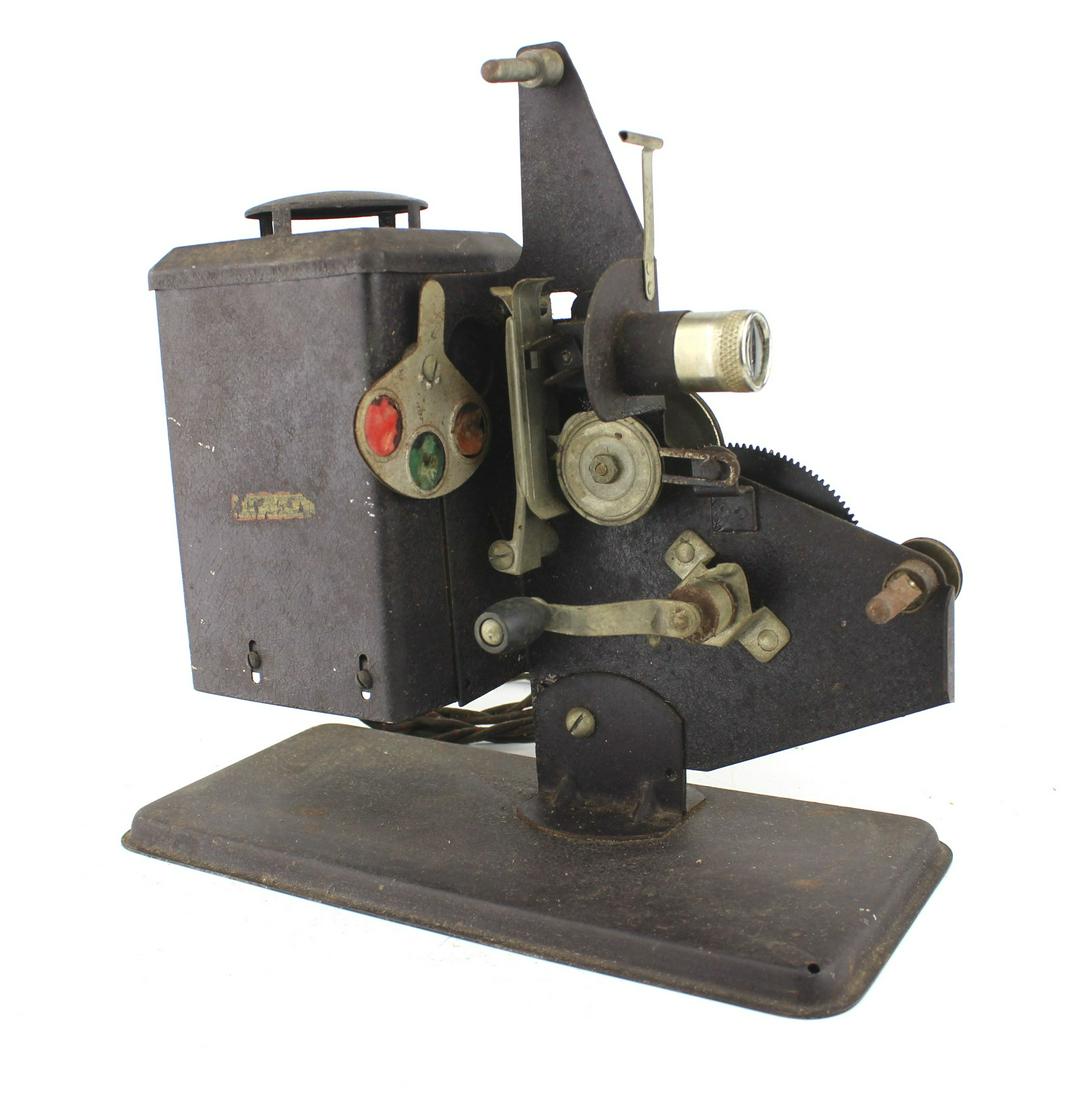 ANTIQUE MANUAL FILM PROJECTOR: 11 X11 X 5 in.. In work condition.