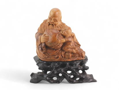 Chinese Carved Boxwood longevity Status with base: A finely carved Chinese boxwood figure depicting Shoulao, the Daoist god of longevity, holding a large peach of immortality, accompanied by a joyous young boy. The carving is rich in detail, especiall