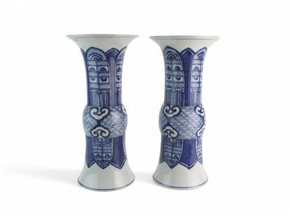 Pair of Large Chinese Blue/white Gu-Form Vases: A pair of Chinese Gu-shaped porcelain vases with underglaze blue decoration, featuring archaistic patterns and cloud motifs. Dimensions: 16 in. H X 7 1/4 in. (D). Age appropriate wear, no visible dama