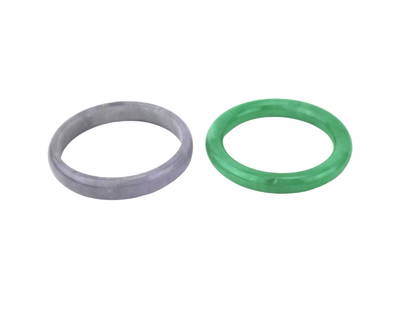 Two Green and Lavender Jadeite Bangles: Pair of jadeite bangles—one in vibrant green with a high polish, and one in soft lavender with a satin finish. Approx. 3 inches in diameter. The green bracelet has minor surface pits; lavender shows