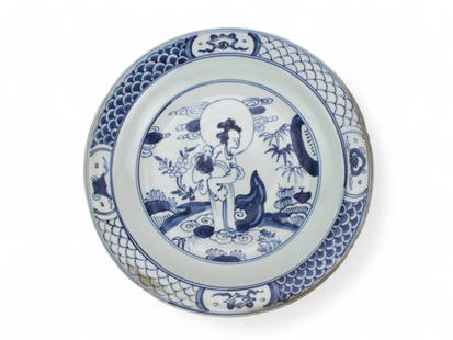 Chinese B/W Porcelain Plate with Immortal Figure: A blue and white porcelain plate depicting an immortal woman with a child, surrounded by floral and landscape motifs. It features traditional border patterns and a Ming Longqing reign mark on the base