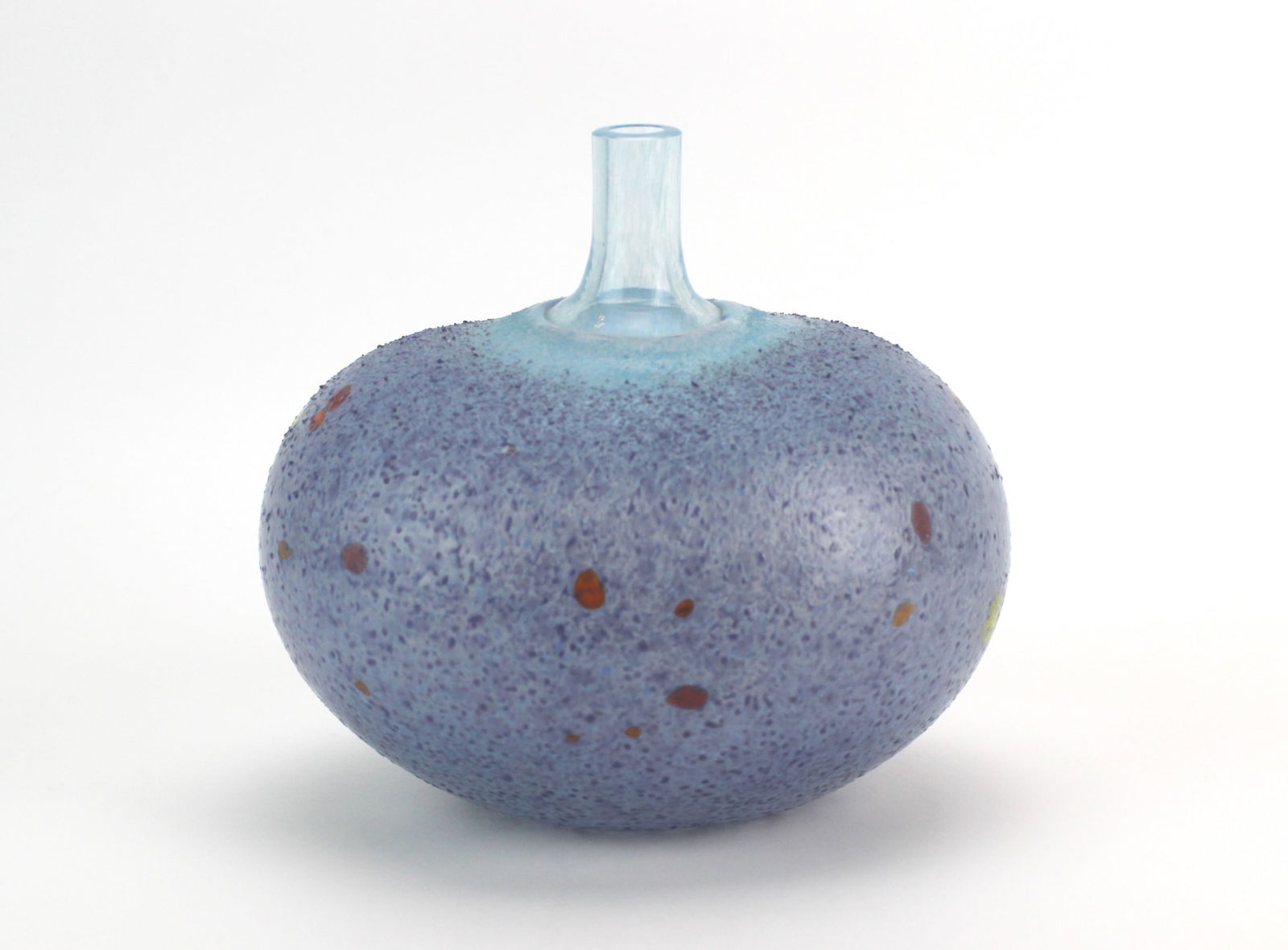 Bertil Vallien Studio Art Oval Bottle Vase: Contemporary studio art oval glass vase by Bertil Vallien for Kosta Boda, featuring a flattened globular form with narrow neck and mottled purplish-blue matte surface accented by multicolor speckles a
