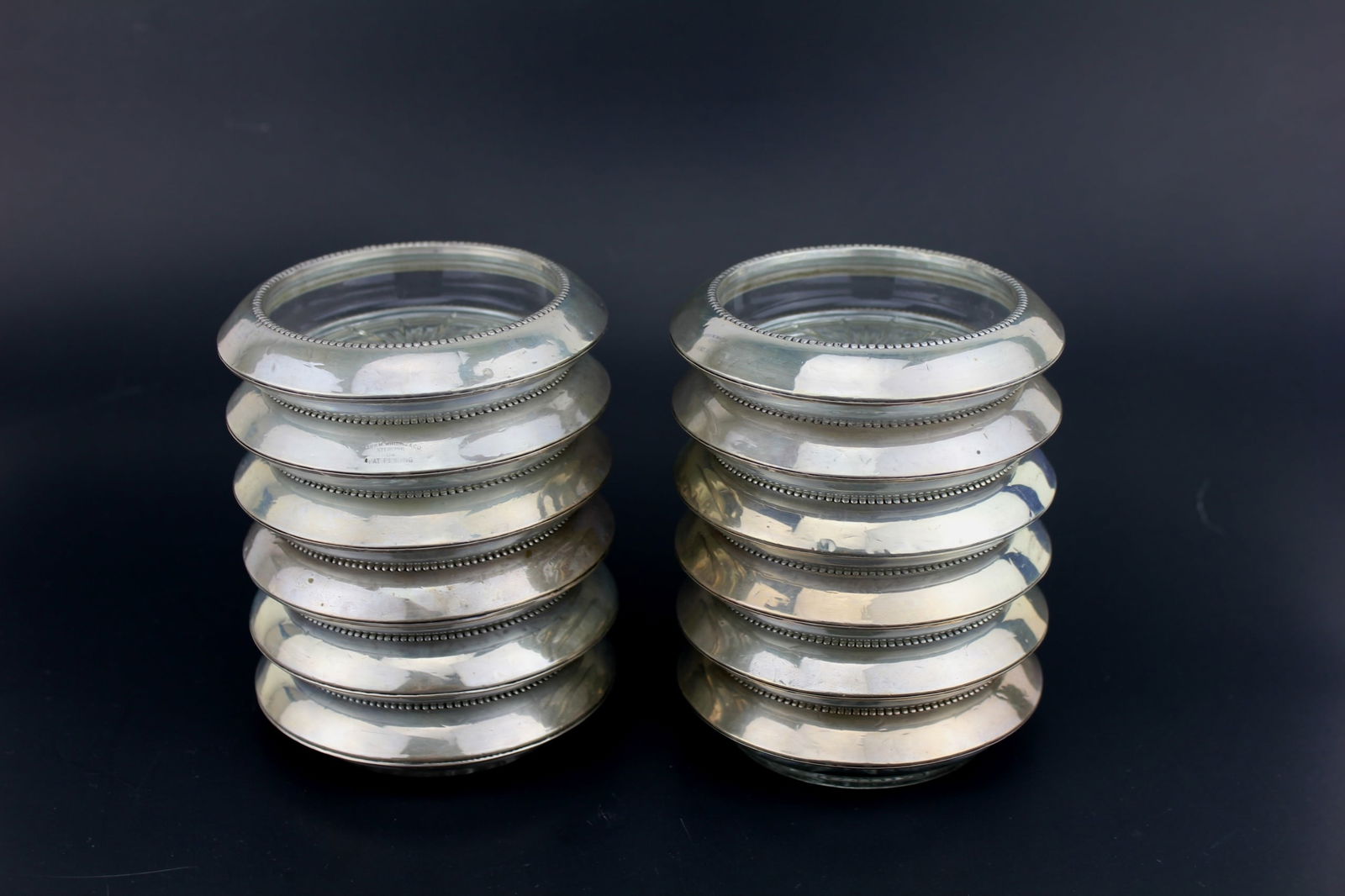 12 Frank M. Whiting & Co. Sterling Glass Coasters: Each coaster measures 4 in. D X 1 in. H. In good condition.