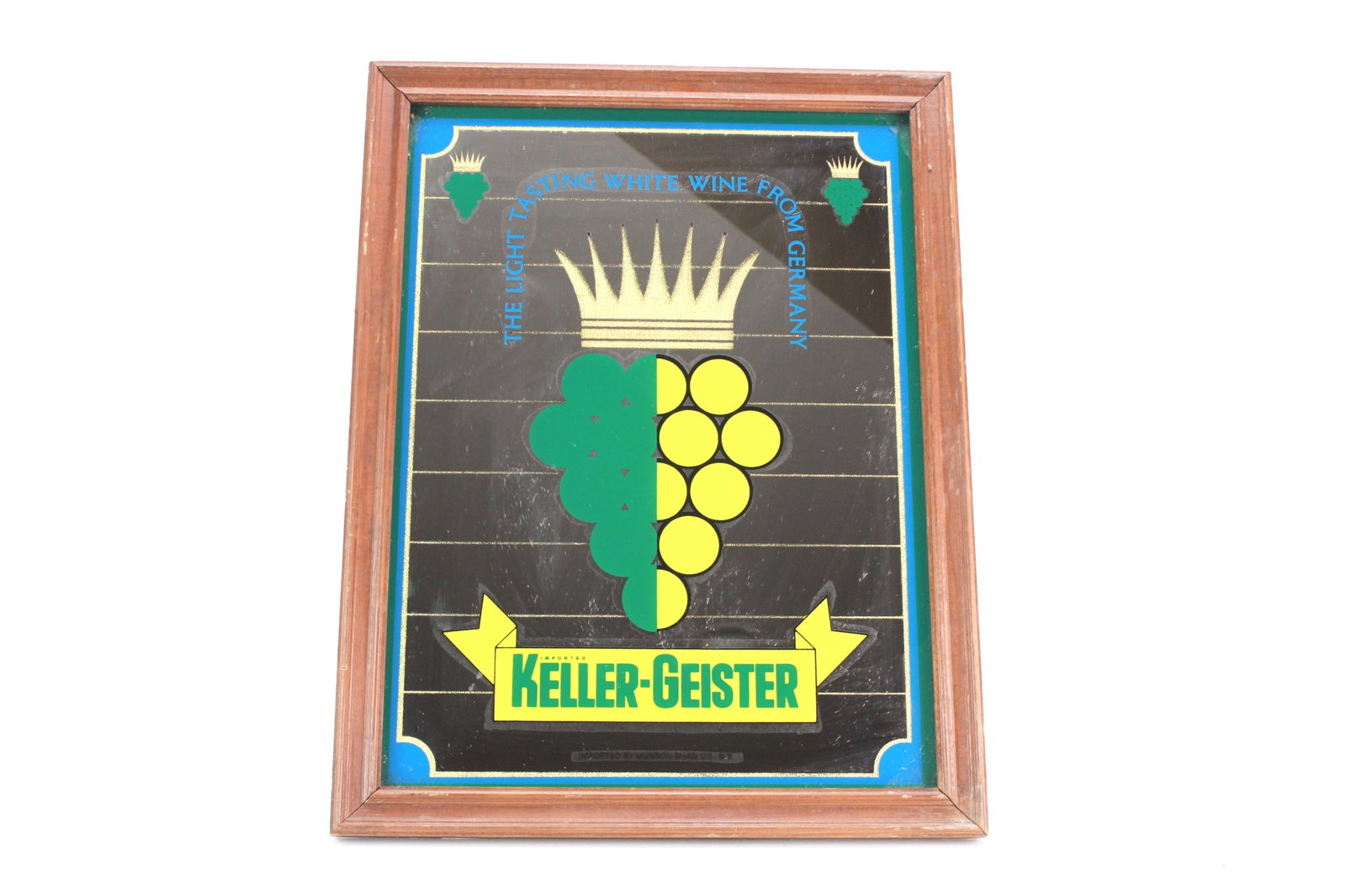 Keller-Geister White Wine Advertising Mirror Sign: Vintage Keller-Geister mirror sign promoting a light white wine from Germany, featuring grape graphics, a crown emblem, and bold text, framed in wood and imported by Munson Shaw Co., N.Y. Dimensions: