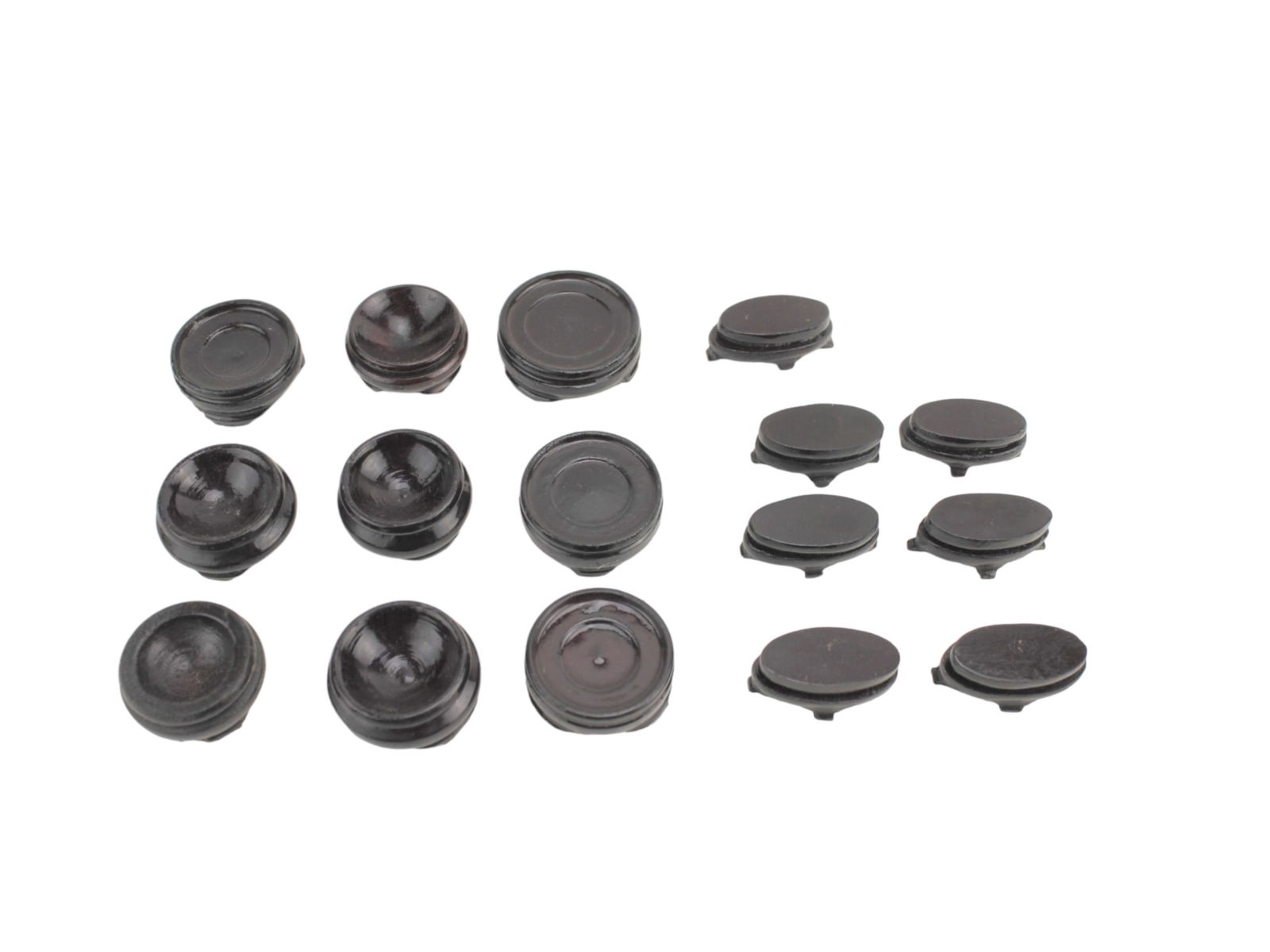 Group of 16 Miniature Carved Wood Stands: Assorted group of 16 miniature carved wood stands, including both round and oval forms with various foot designs. The largest stand measures approximately 1 1/2 in. (L). Surfaces show typical age-rela