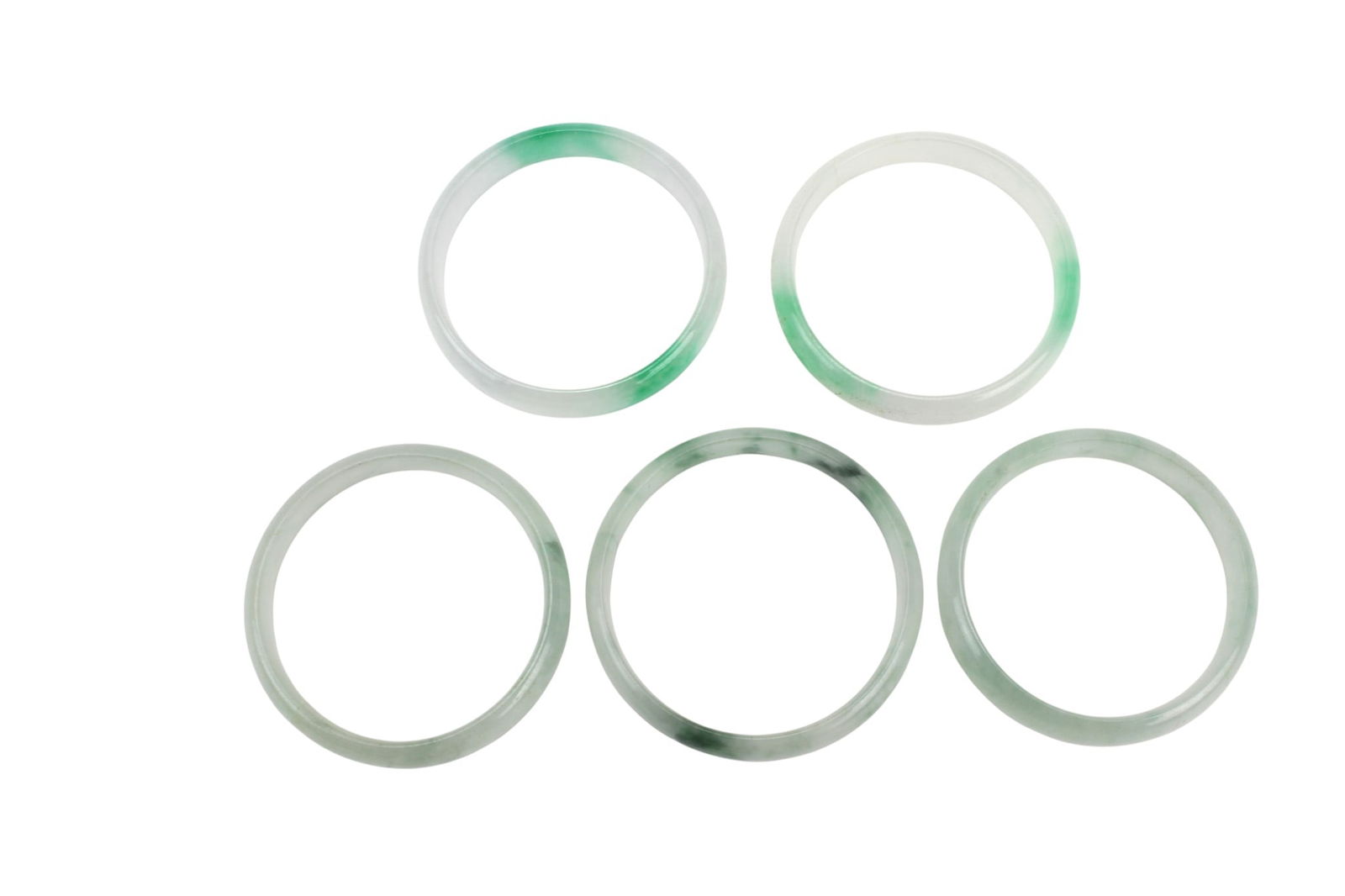 Five Green Jadeite Rings: summarize itFive Jadeite Rings. Pale green and white tones with natural mottling. Largest approx. 51.1 mm outer × 43.2 mm inner diameter. Good condition with light wear and natural inclusions.