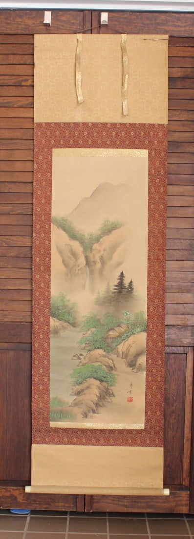 Asian Watercolor on Silk Scroll: Depicting mountain and forest. Signed and chop stamped lr. With wood case. Painting measures Approx. 14 1/2 X 41 in., the scroll measures Approx. 20 1/2 X 70 in..
