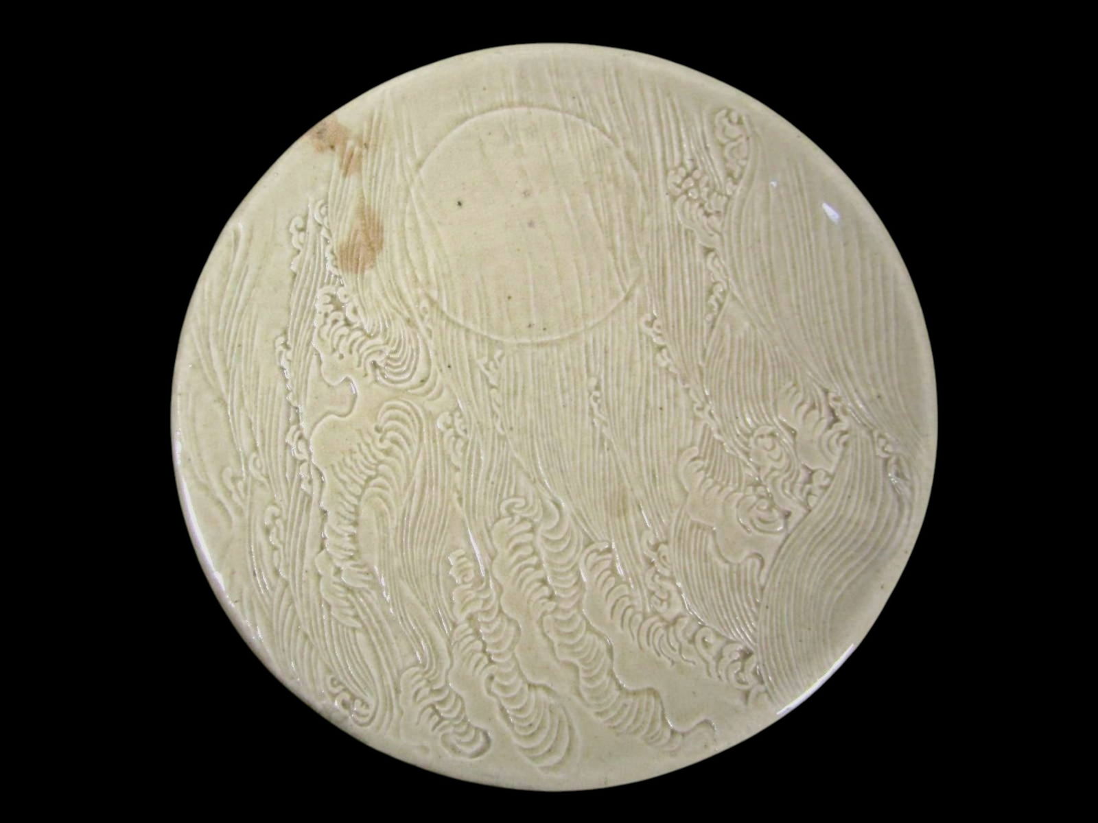 Celadon Carved Wave Motif Porcelain Platter: Celadon-glazed porcelain platter featuring finely carved wave and flowing water motifs beneath a soft translucent glaze. The shallow form with gently flared rim highlights the detailed carving,