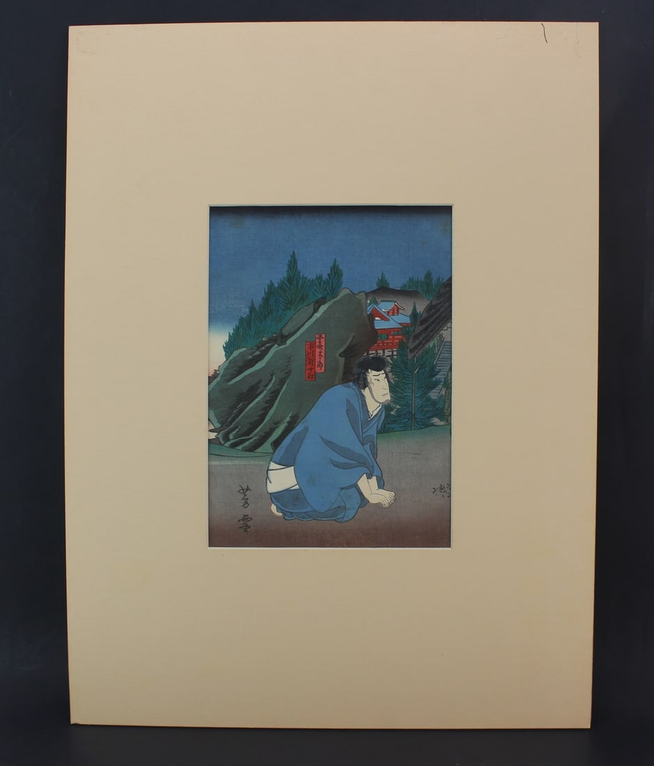 Yoshiyuki Woodblock with Crouching Man, ca. 1856: Original Japanese woodblock print by Yoshiyuki, circa 1856, depicting a crouching male figure in blue robes with detailed background architecture and foliage. Matted presentation board measures 20.5