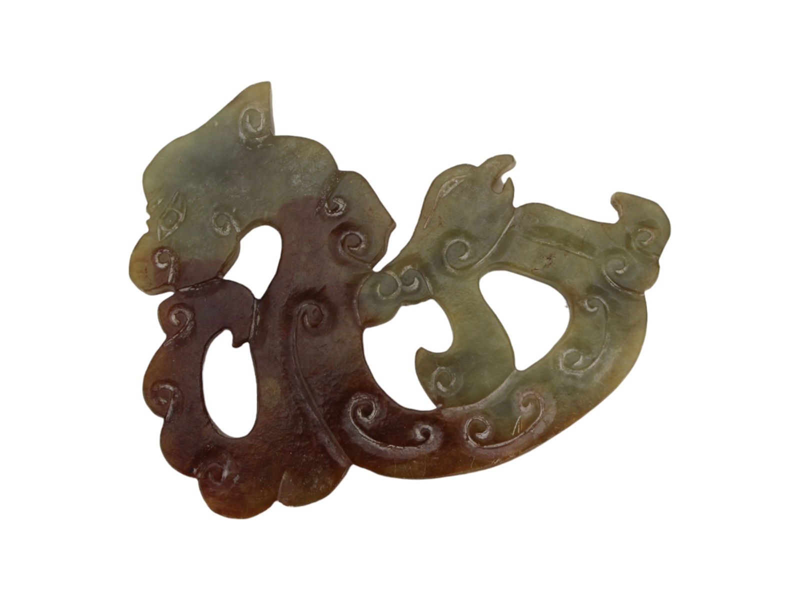 Chinese Archaic Style Carved Jade Ornament: This piece features a finely carved jade ornament in a light to dark green hue with intricate cloud and swirl motifs. The design incorporates fluid, stylized lines that suggest mythical creatures or