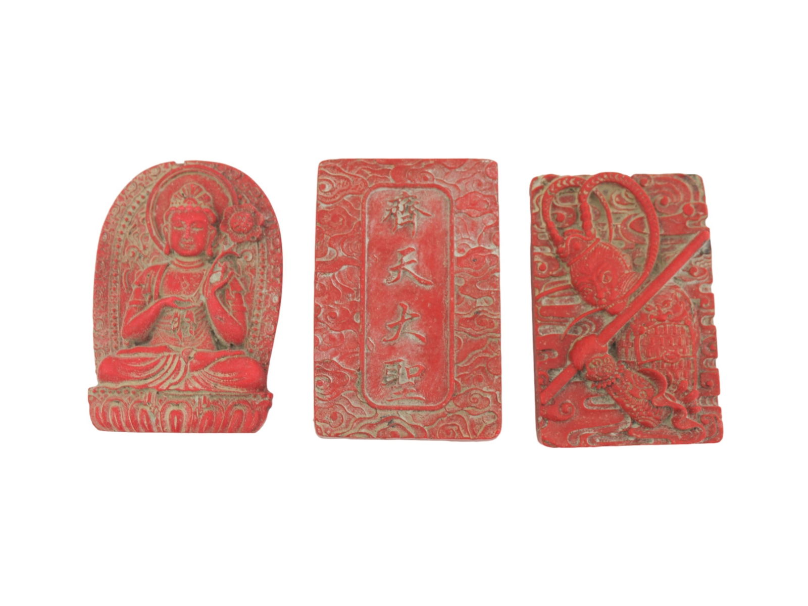 Trio of Red Lacquer Carved Pendants: A set of three red lacquer carved pendants featuring a bodhisattva, the Monkey King, and Chinese characters with cloud motifs. Each piece is finely detailed. The largest one measures approx. 2 1/4 X