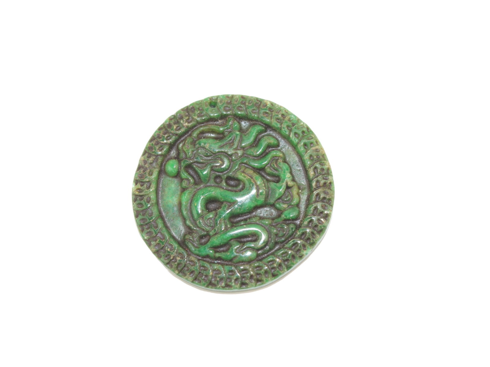 Dark Green Jade Pendant with Dragon Motif: A Chinese round dark green jade medallion intricately carved with a dragon in high relief, bordered by a decorative pattern. The back is smooth with a small hole, likely for hanging. Approx. 1 3/4