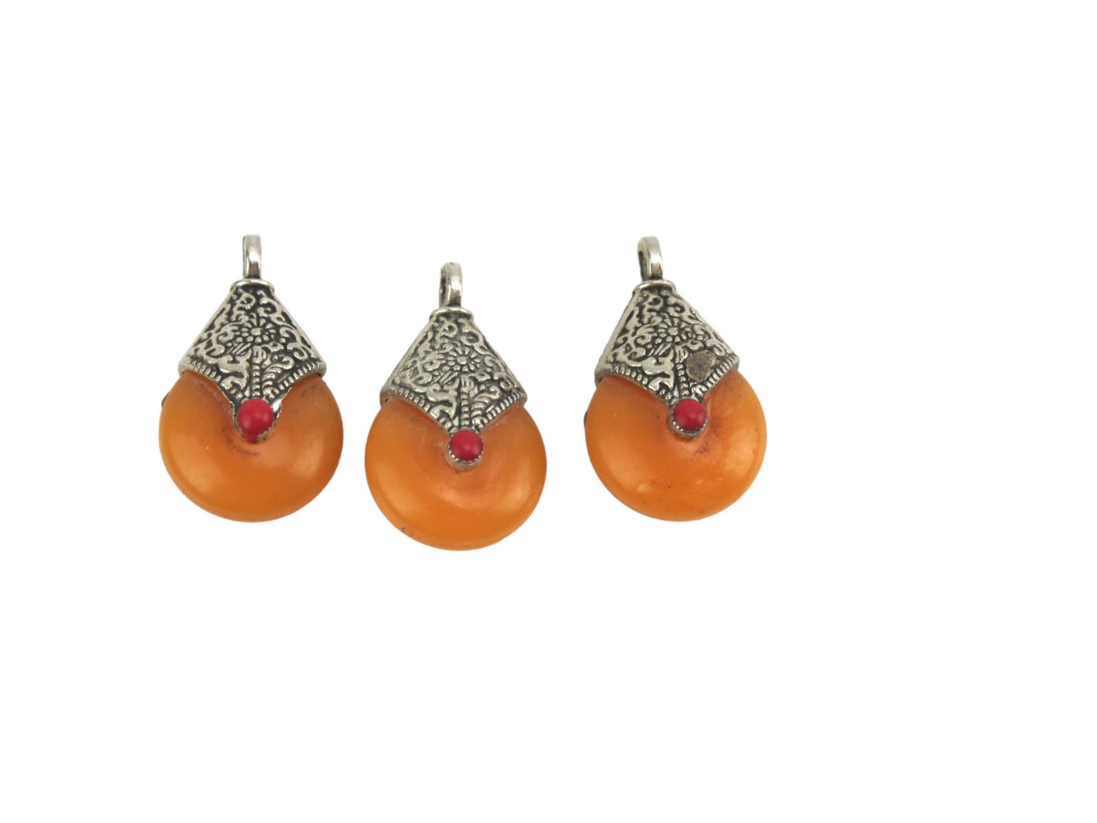 Set of Three Amber-Style Drop Pendants: A set of three amber-colored drop pendants, each with an ornate silver-toned cap and accented with red and turquoise cabochons. Each measures approx.1 1/4 in. L..