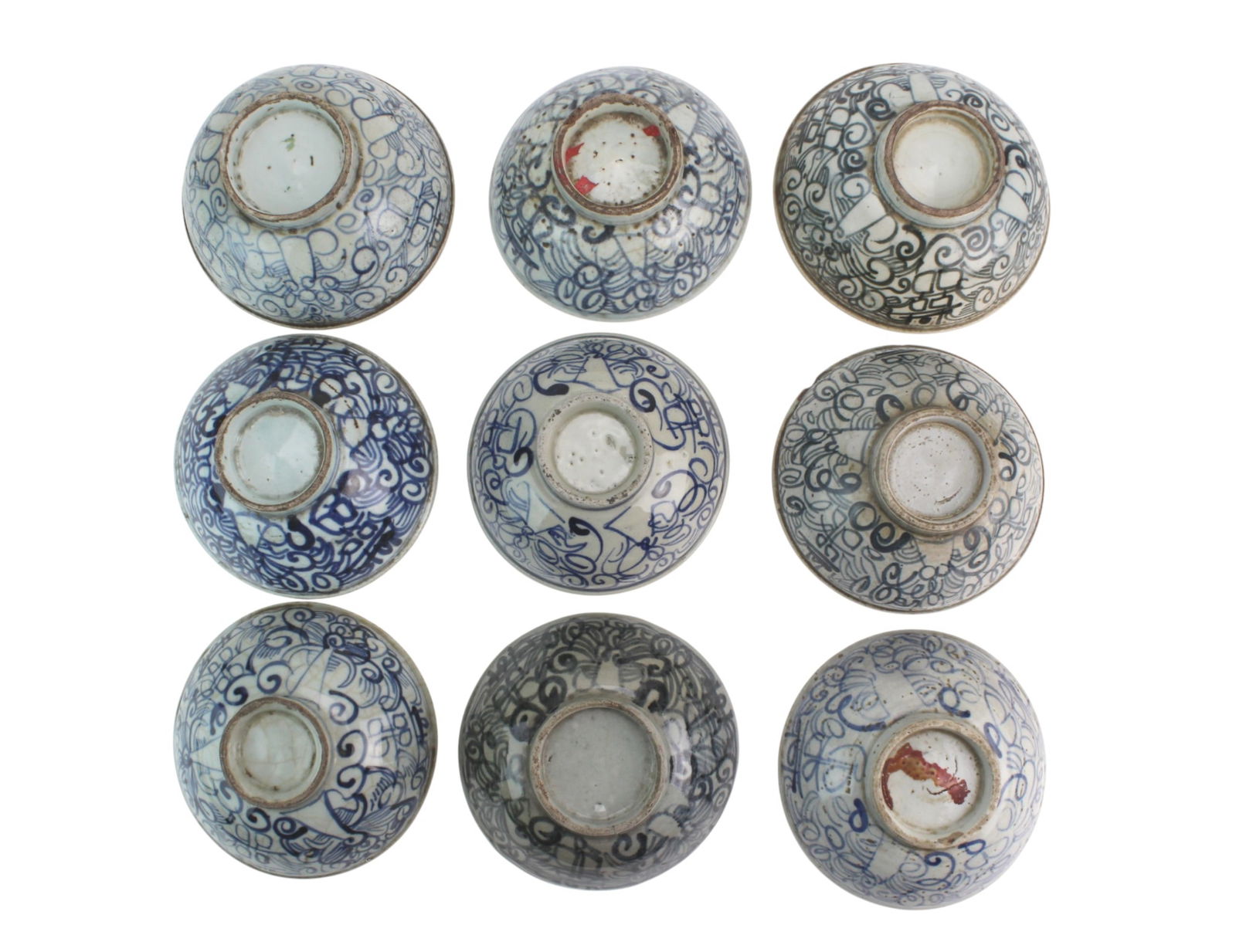 Nine Chinese Blue & White Porcelain Bowls: A group of nine antique blue-and-white bowls with hand-painted scrolling designs. The largest measures 6 1/2 in. (D) × 2 3/4 in. (H). Condition varies: glaze wear, firing flaws, interior staining,