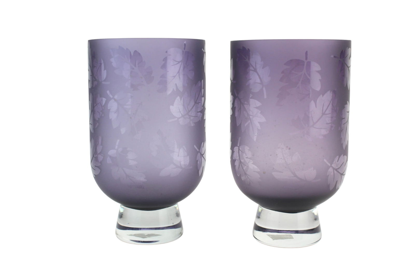 Pair of Purple Etched Glass Vases: Decorative pair of purple art glass vases with etched leaf motif and clear glass bases. Each measures approx. 4 1/2 in. (D) x 7 3/4 in. (H). Both are in good condition, showing light surface wear and