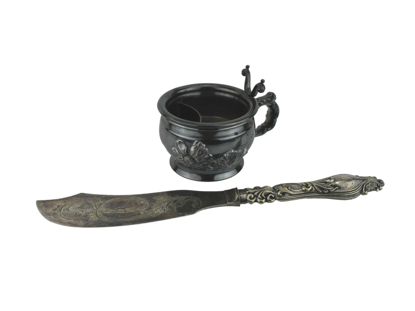 Victorian Silver Plated Fish Knife and Salt Cellar: A pair of Victorian-era silver-plated table items. The fish knife (in12 1/4 in. L) features an ornate floral scroll design and a central engraved fish motif on the blade. The companion piece is a lidd