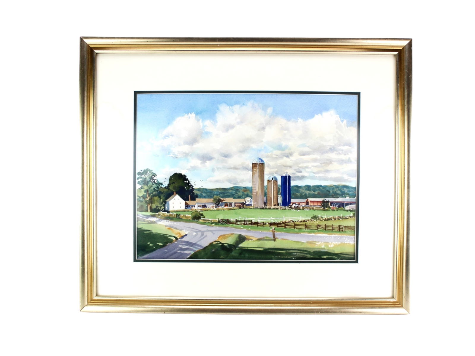 Framed W/C Painting of a Countryside Farm Scene: Framed watercolor painting depicting a serene countryside farm with silos, barns, a farmhouse, and green pastures beneath a bright sky. Presented in a gold-tone frame with white matting. Anonymous. Si