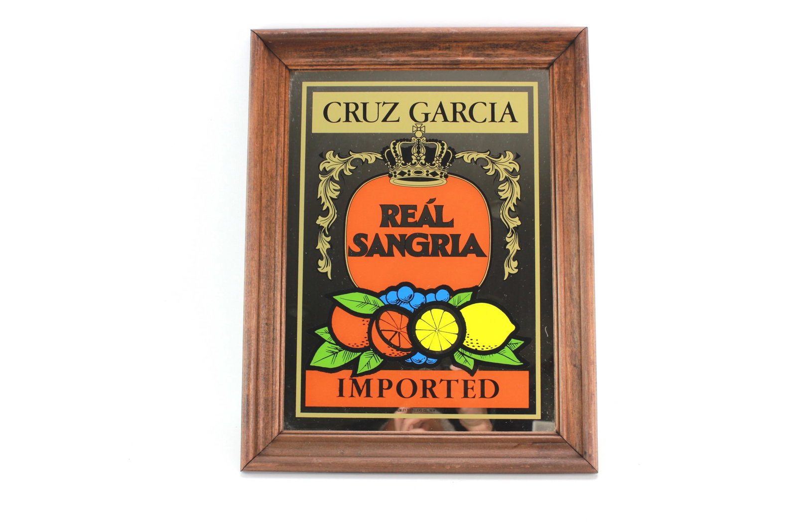 Cruz Garcia Real Sangria Imported Wall Mirror Sign: Vintage mirror sign for Cruz Garcia Real Sangria, featuring bold fruit graphics and "Imported" branding, set in a wooden frame. Marked by Schenley Distillers Co., New York. Dimensions: 13 1/2 in.