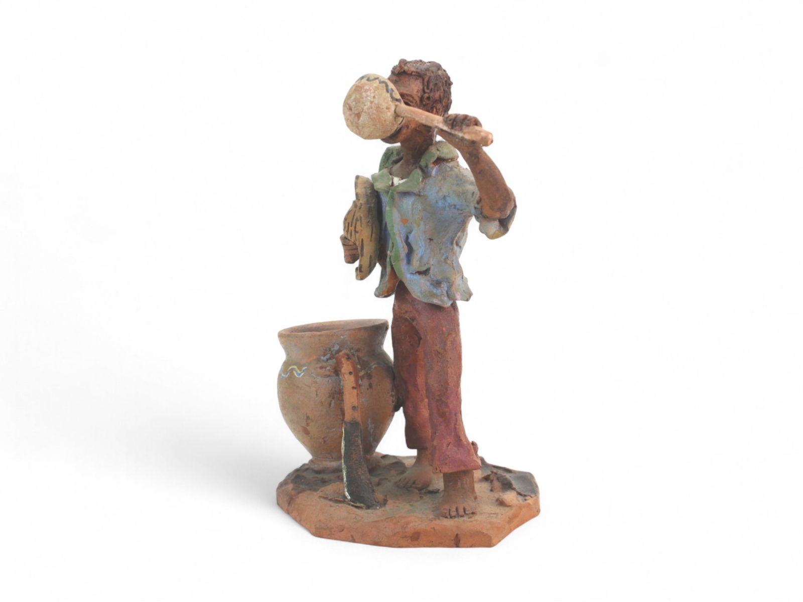 Pottery Sculpture of Man with Jug and Pot: Rustic pottery sculpture of a barefoot man drinking from a jug beside a vessel, signed "Mendes Ceramic Castaner P.R." Shows minor wear. Measures 8 1/2 in. (H) X 5 1/2 in. (L) X 4 1/2 in. (W)