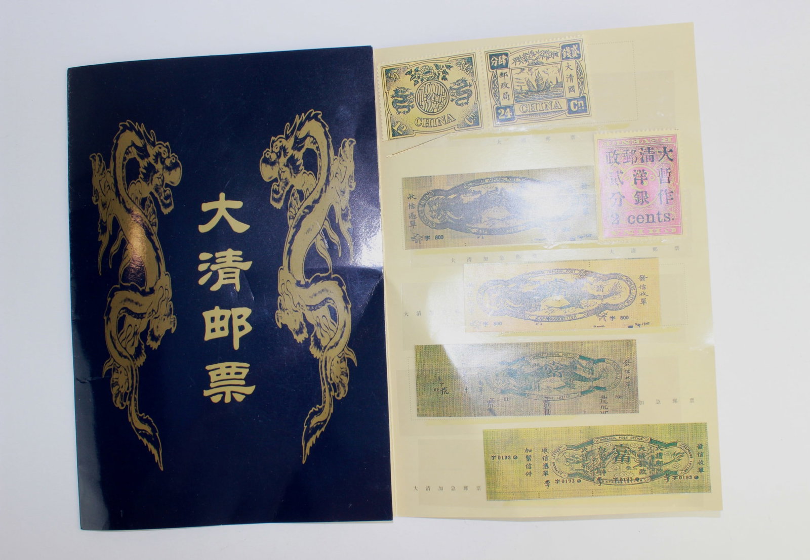 Chinese Stamp Print Collection (119 Designs): A detailed printed folio featuring 119 various Chinese Imperial stamp designs, including early Qing Dynasty motifs, overprints, and specimen marks. The print is presented in a glossy navy and gold