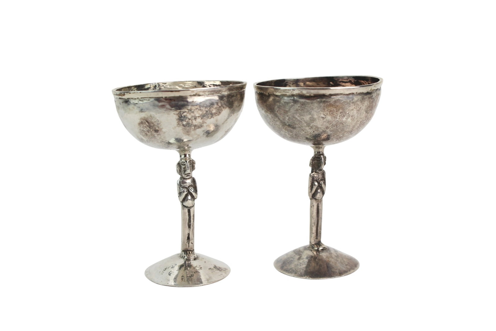 Pair of Silver Stemmed Figural Cups: Pair of silver stemmed cups with hammered bowls and figural stems, marked with decorative emblem. Size: 3 3/4 in. (H) ? 2 1/2 in. (D); total weight approx. 135.4 grams. Condition: heavy tarnish,