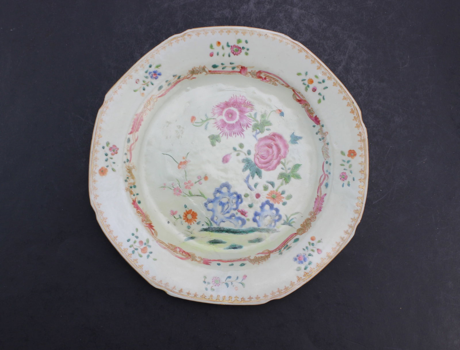 Chinese Famille Rose Porcelain Plate: Chinese famille rose porcelain plate decorated with floral motifs and gilt accents. Measures 9 in. (D). Shows surface wear and minor glaze imperfections consistent with age; with old restoration and