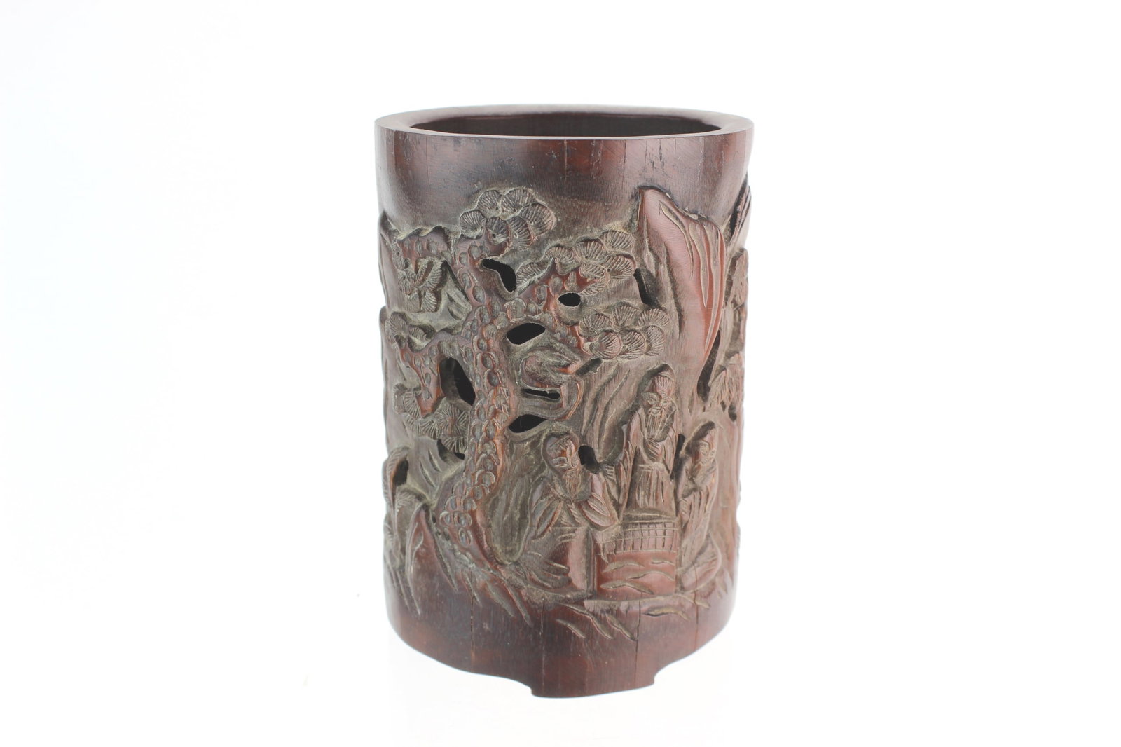Chinese Carved Bamboo Brush Pot: Chinese bamboo brush pot carved in deep relief with a scholarly landscape of figures, trees, and mountains; rich aged patina with visible age cracks on rim and base. Measures 6 1/2 in. (H) X 4 1/2