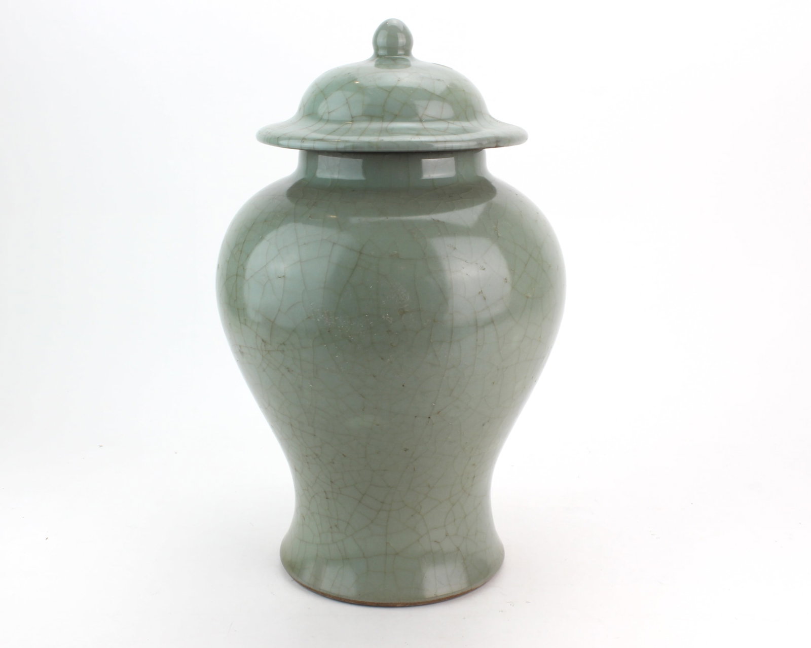 Chinese Celadon Crackle Glazed Lidded Jar: Chinese celadon glazed porcelain lidded jar of baluster form, covered overall in a pale green glaze with a prominent crackle pattern. Fitted with a domed cover with rounded finial and broad flared rim